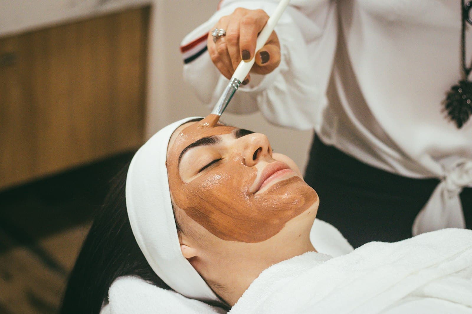 A clay mask being applied during a facial treatment at MARMO