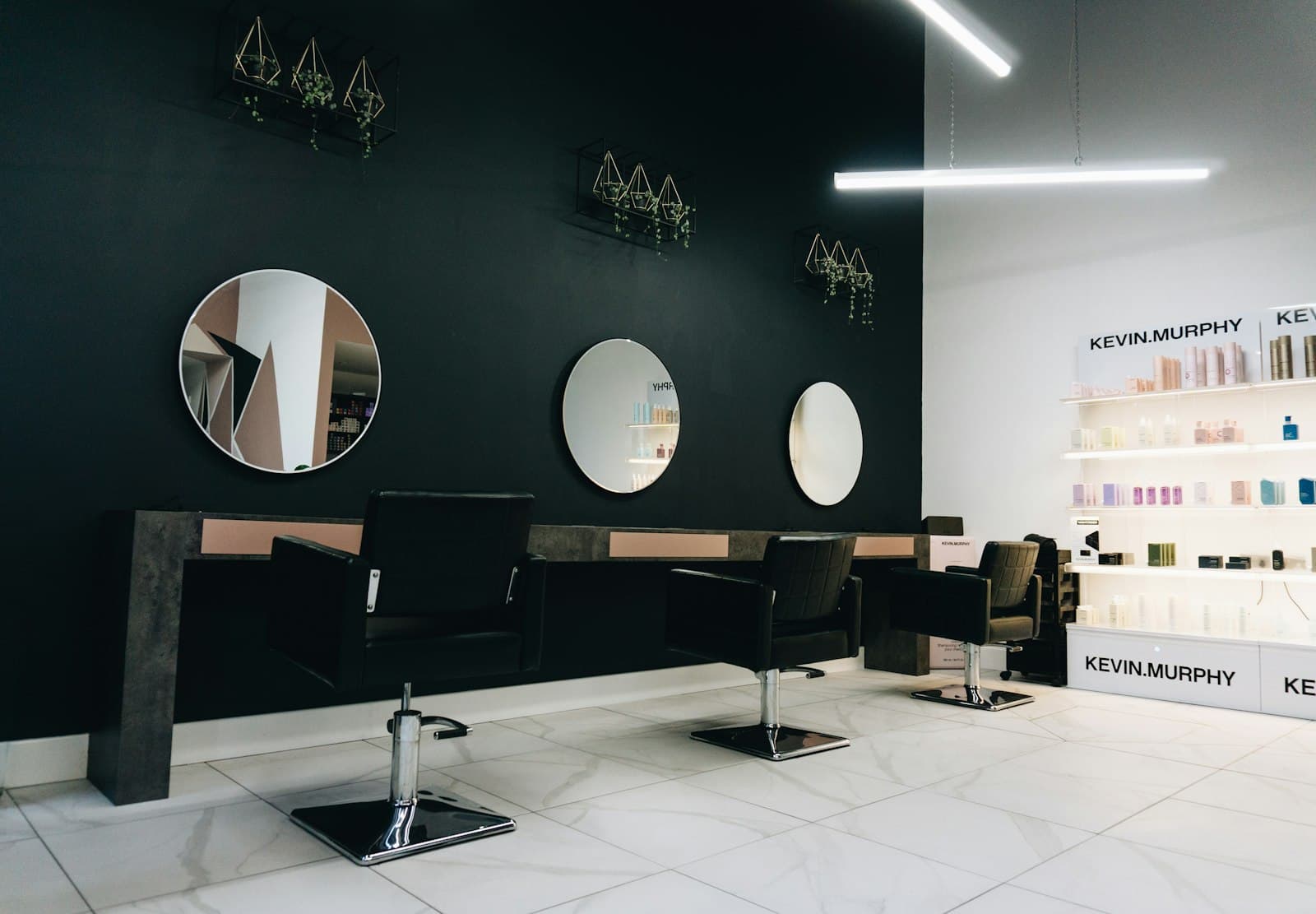 The MARMO studio floor: black stations, round mirrors, veined marble tile